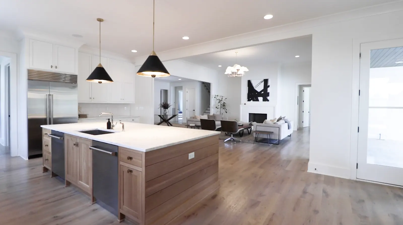 Open plan kitchen with marble island and pendant lighting